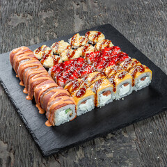 Japanese cuisine. Seafood, vegetables and meat. Sushi and rolls big set isolation on a wooden table background