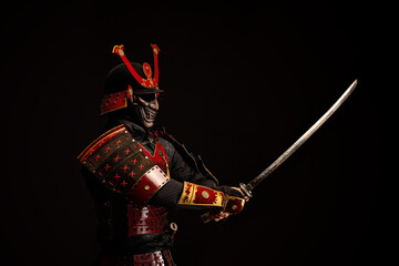 Portrait of a samurai in armor in attack position - obrazy, fototapety, plakaty