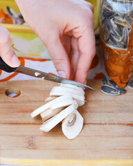 human a hands cut mushrooms with a sharp knife