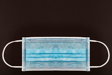 blue medical or Surgical face Mask. Virus Protection. Black background. Space for entering text 