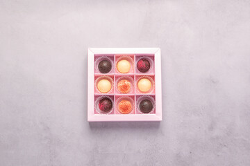 Chocolate candies in a festive box on a gray background. Holiday concept. Minimalism food dessert. Horizontal frame