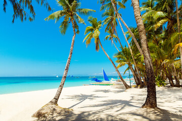 Beautiful landscape of tropical beach on Boracay island, Philippines. Coconut palm trees, sea, sailboat and white sand. Nature view. Summer vacation concept.