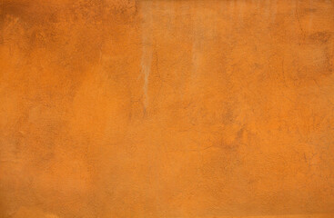 Orange color stucco background or texture. Bright light plastered wall of a building.