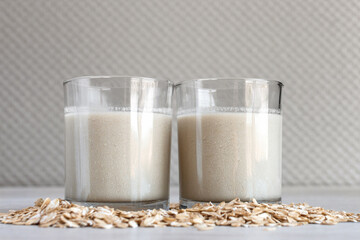 Close up vegan oat milk in small drinking glass with seed