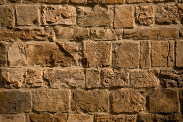 Antique brick wall in sunligh. Cracked and scratched on brown masonry or brickwork. Close up shot. Abstract background or texture.