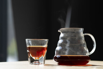 brewing coffee in a funnel. glass teapot with specialty of freshly brewed coffee. on a beautiful table, the kettle is steaming. brewing coffee. here