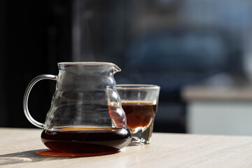 brewing coffee in a funnel. glass teapot with specialty of freshly brewed coffee. on a beautiful table, the kettle is steaming. brewing coffee. here