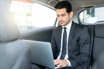 Businessman Using Laptop In Taxi