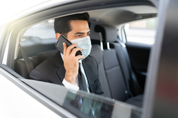 Businessman With Face Mask In Taxi During Coronavirus Crisis