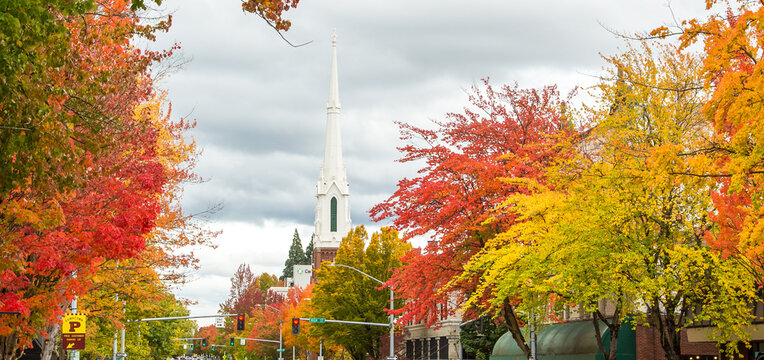 Salem, Oregon, a street scene in downtown Salem with trees exhibiting brilliant fall colors and the Methodist church steeple showing in the background.