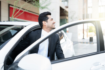 Fototapeta na wymiar Smiling Male Executive Getting Out From Car