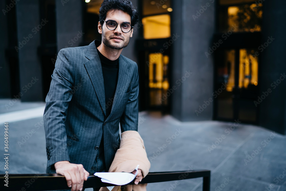 Aufkleber half length portrait of successful male traer with paper documentation in hands smiling at camera wh