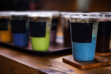 variant of cold drinks with fruit flavor. fresh cafe menu with dark background. colorful ice mockups with plastic cups. grape, chocolate, strawberry, mango, grass jelly,  blueberries, guava