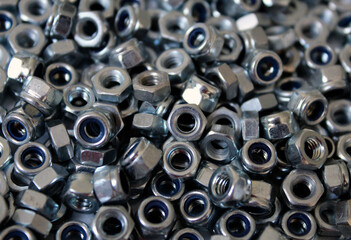 Background from heaps of metal nuts. A handful of metal nuts