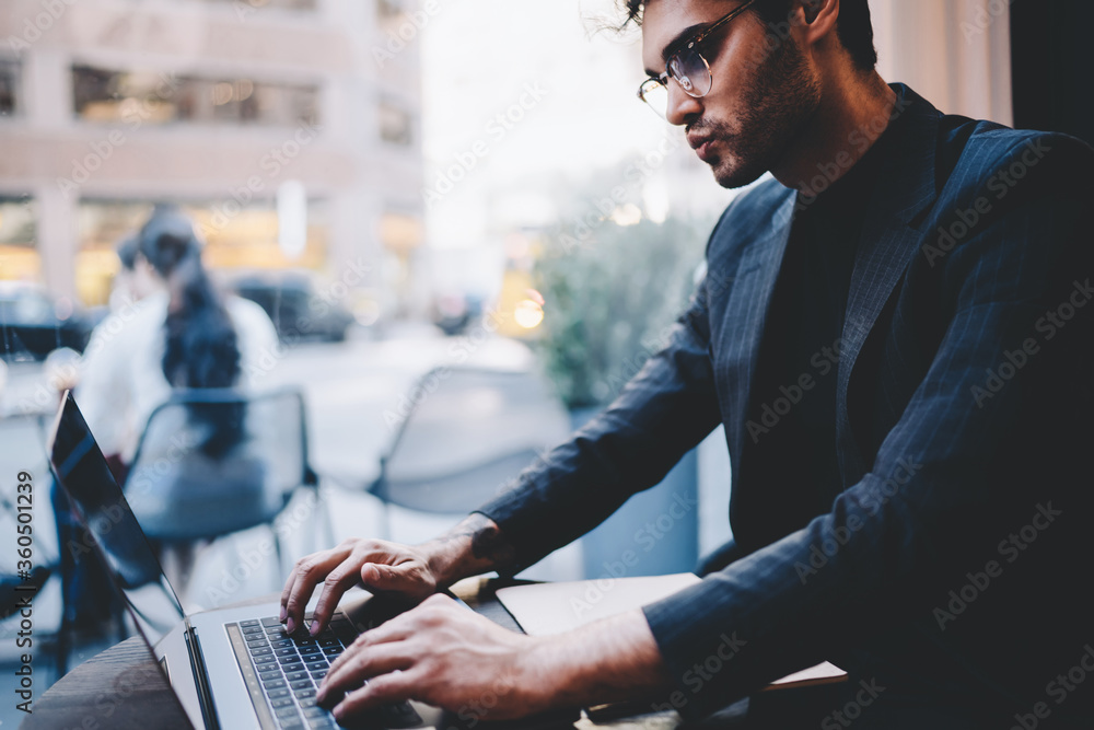 Aufkleber concentrated male entrepreneur in trendy wear and spectacles typing documentation for software, pros