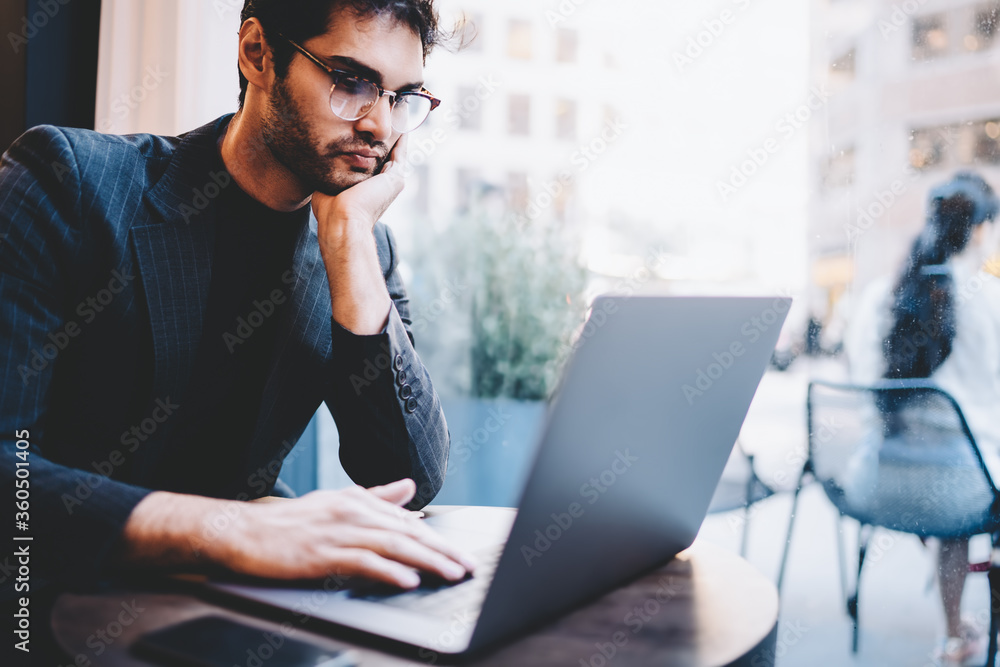 Aufkleber pensive male financial manager searching information data on modern laptop computer connected to wir