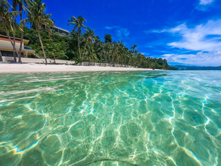 Beautiful landscape on the tropical beach of Boracay island, Philippines. Coconut trees, sea, sailboat and white sand. View of nature. The concept of summer vacation.