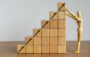 Business concept growth success process. Wooden model of human arranging wood block stacking as step stair on wooden table. Beautiful white background, copy space.