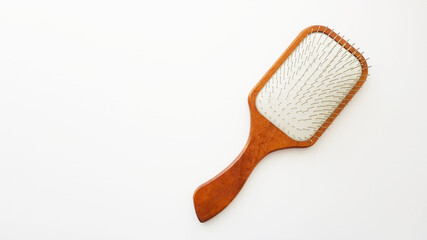 Large wooden massage hair brush with iron bristles on the white table.
