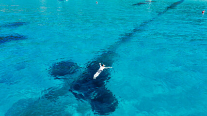 Fototapeta na wymiar Aerial view of swimmer swimming in the crystal clear ocean