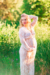 Beautiful young pregnant woman relaxing in nature on a beautiful sunny day.