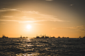 Naklejka na ściany i meble Boats sunset over the sea