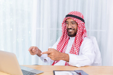 Arabian businessman smile and happy from message his computer notebook in his office