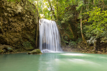 Fototapeta na wymiar Long exposure short of Erawan waterfalll, a beautiful tropical waterfall in Thailland