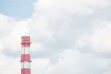 Coal power plant smokestacks emit carbon dioxide pollution by factory under blue sky.