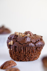 Healthy muffin homemade freshly baked and gluten free with pecans and cocoa powder isolated on white background, nutrition concept
