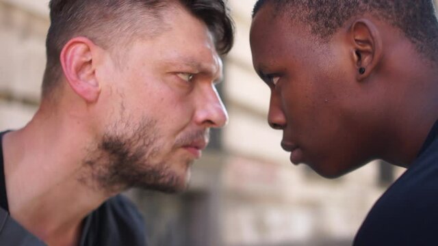 Angry african-american man across from the caucasian man, conflict between male students, bullying and discrimination, stop racism, protests against racial hatred and discrimination