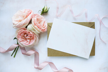 vintage background with roses and paper. postcard mockup. a small bouquet of pink roses and an envelope. wedding invitation. greeting card