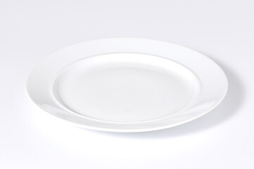 An empty white enamel plate placed on a white background