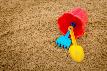 Children's games during quarantine in the sandbox. A medical mask, a shovel, a rake and a bucket for games on the street to lock down, a ban on travel to quarantine, local rest