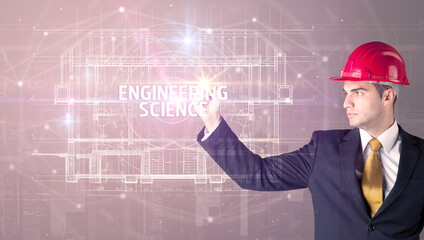 Handsome architect with helmet drawing ENGINEERING SCIENCE inscription, new technology concept
