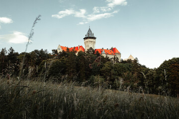 Beautiful scenic view of Castle Smolenice in Europe (Slovakia) on sunset. Fairy tale  old and ancient castle with on meadow. Horizontal photo of romantic castle with dramatic cloudy sky.