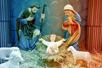 Statuettes of Mary, Joseph and baby Jesus,The birthday of Jesus is a statuette of Maria with Joseph and newborn Jesus on the hay, A Christmas nativity scene.