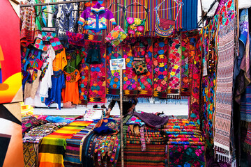Colorful handmade handicrafts of different colors in indian market of Otavalo in Ecuador