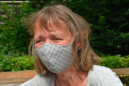 seniorin mit atemschutzmaske  wegen corona-krise
