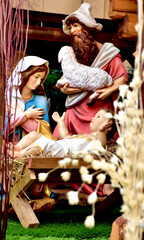 Fototapeta na wymiar Statuettes of Mary, Joseph and baby Jesus,The birthday of Jesus is a statuette of Maria with Joseph and newborn Jesus on the hay, A Christmas nativity scene.