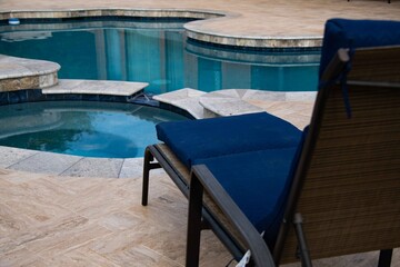 Blue lounge chairs on a travertine spa deck.