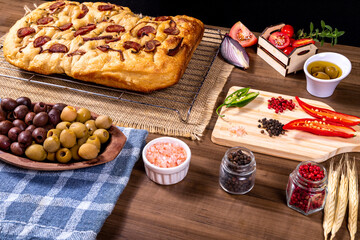 Traditional Italian Focaccia with pepperoni, cherry tomatoes, black olives, rosemary ando onion - homemade flat bread focaccia