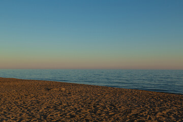 View of a beach on the Italian coast in the Tyrrhenian Sea, in Lazio, at sunset. Sunset over the beach.