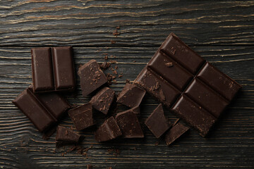Tasty chocolate on wooden background, top view