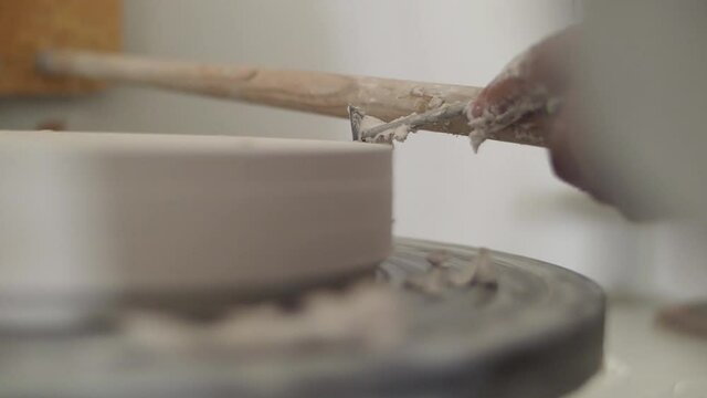 man modeling ceramic casting pottery with tools on a wheel slow motion