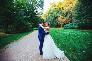 Newlywed couple in the park. Just married. Walk in the park and hug.