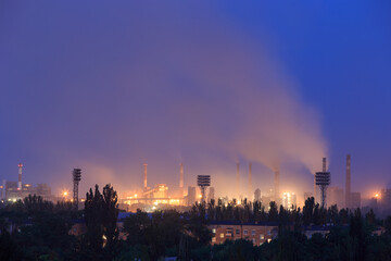 Evening in the city with a large metallurgical plant on the outskirts