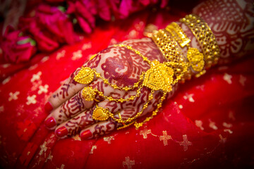 A bride's hand full of gold ornaments. Indian Wedding.