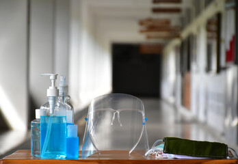 New normal, Hand sanitizer gel, faceshield and facemasks in front of the office for cleaning hands and wearing on face before getting inside to protect and prevent Coronavirus or Covid-19 and germs.