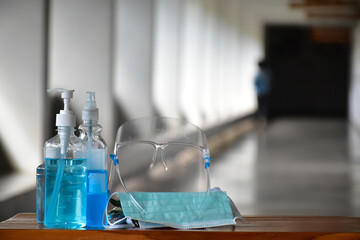 New normal, Hand sanitizer gel, faceshield and facemasks in front of the office for cleaning hands and wearing on face before getting inside to protect and prevent Coronavirus or Covid-19 and germs.